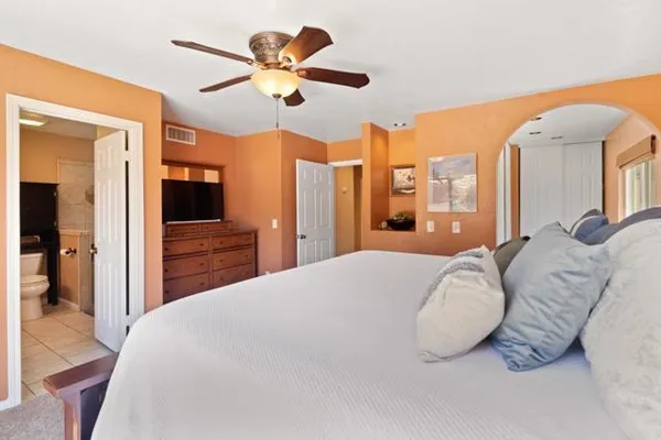 a bedroom with a large bed and a chandelier