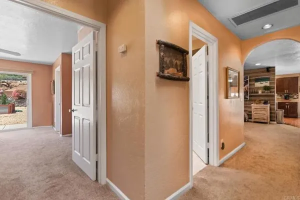 a view of a hallway with closet and a living room