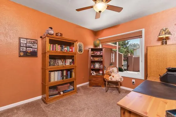a view of a workspace with furniture and a book shelf