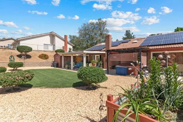 a front view of a house with a yard and potted plants