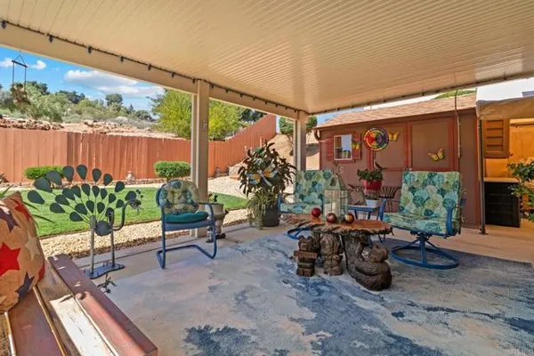 a living room with patio furniture and a potted plant