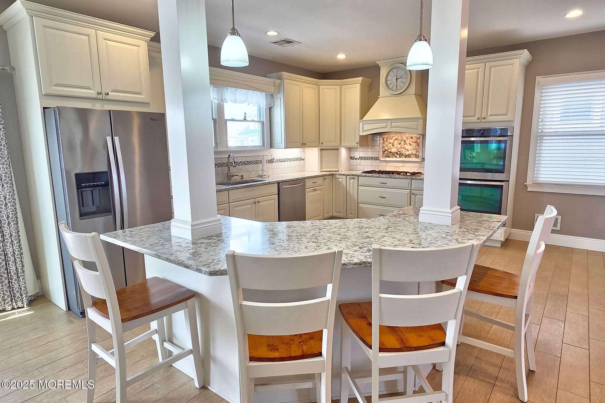417 Delray Drive Lavallette, NJ 08735 - Photo 12 of 71 a kitchen with granite countertop a table chairs microwave and cabinets