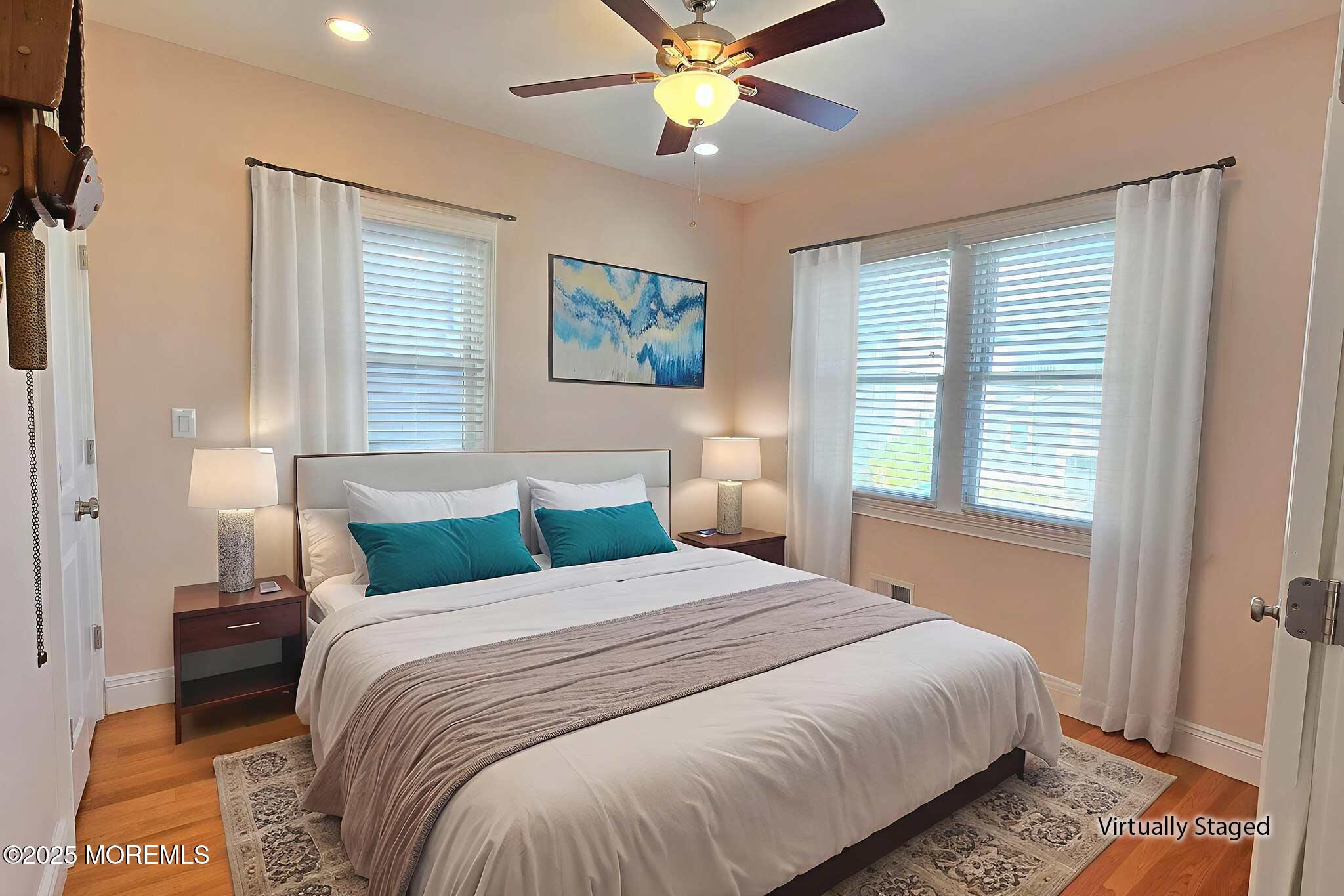 417 Delray Drive Lavallette, NJ 08735 - Photo 25 of 71 a bedroom with a bed and a chandelier