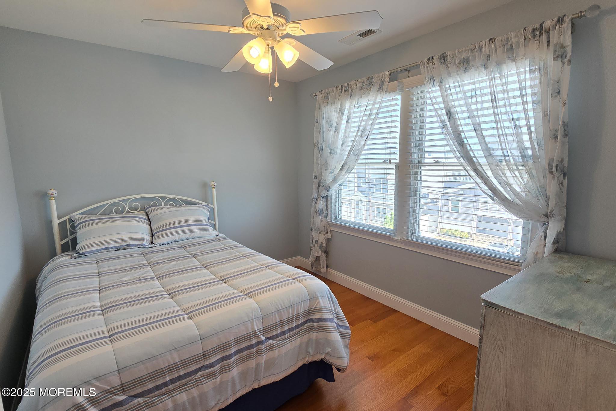 417 Delray Drive Lavallette, NJ 08735 - Photo 43 of 71 a bedroom with a large bed and a chandelier