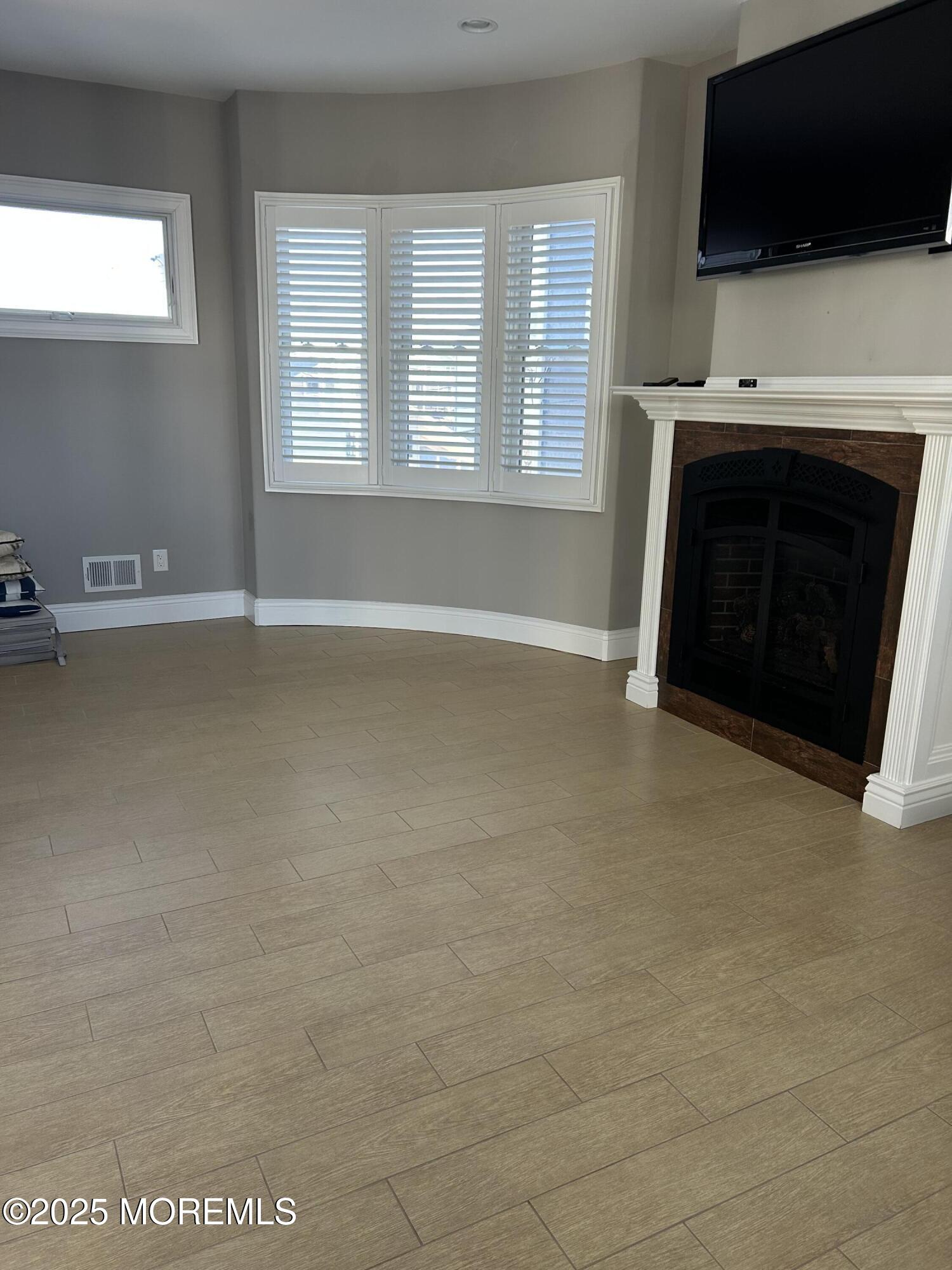 417 Delray Drive Lavallette, NJ 08735 - Photo 63 of 71 a living room with a fireplace a flat screen tv and a window