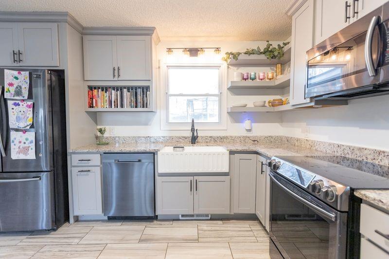 5028 Bird Road Gainesville, GA 30506 - Photo 12 of 34 a kitchen with stainless steel appliances granite countertop a sink stove and cabinets
