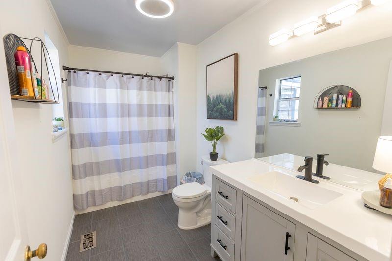 5028 Bird Road Gainesville, GA 30506 - Photo 18 of 34 a bathroom with a sink a toilet and shower curtain