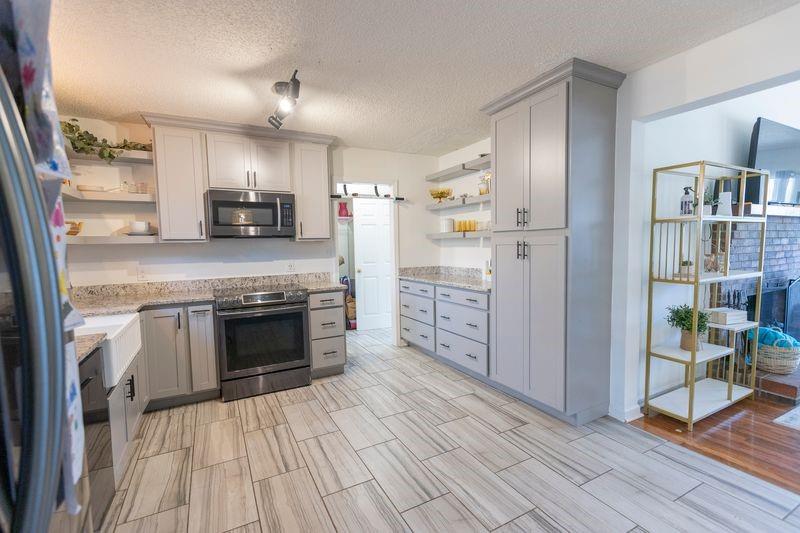 5028 Bird Road Gainesville, GA 30506 - Photo 10 of 34 a kitchen with stainless steel appliances a stove refrigerator and a fireplace