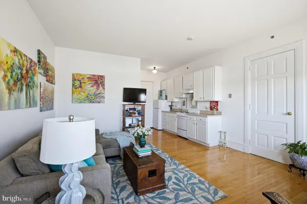 a living room with furniture kitchen view and a window