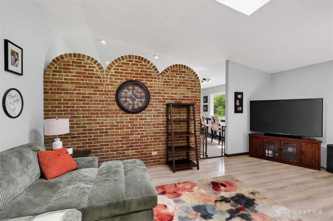 2165 Stewart Road Xenia, OH 45385 - Photo 15 of 59 This living area features a distinctive brick accent wall with arched details and light wood flooring.