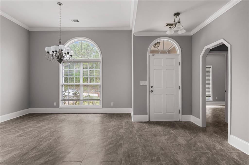 1449 Cummings Road Smiths Station, AL 36877 - Photo 5 of 28 Arched entry door with transom window, tile flooring, arched interior doorway, and crown molding