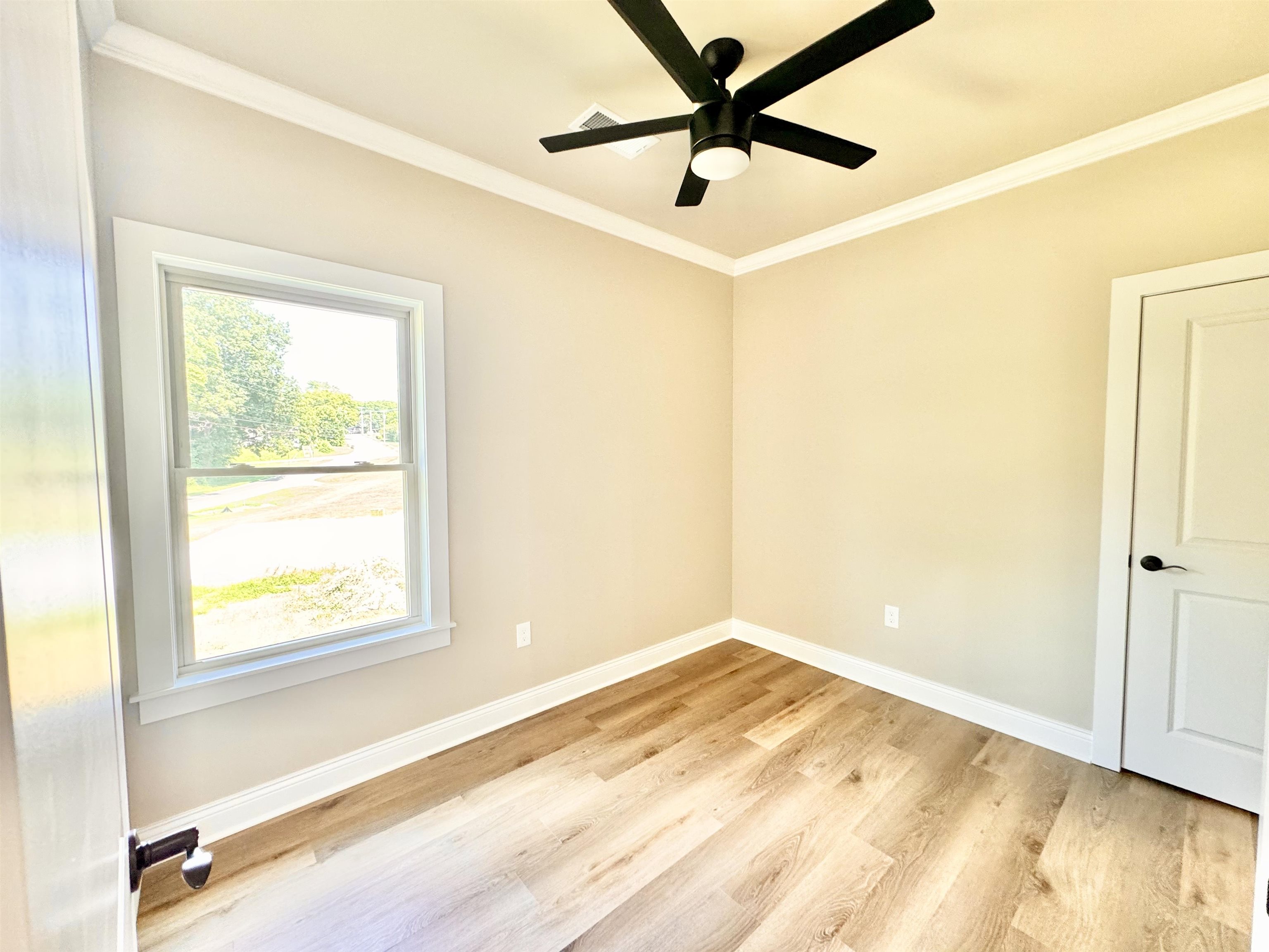 210 Church Street Ripley, TN 38063 - Photo 11 of 14 Spare room featuring ceiling fan, crown molding, and light wood-type flooring