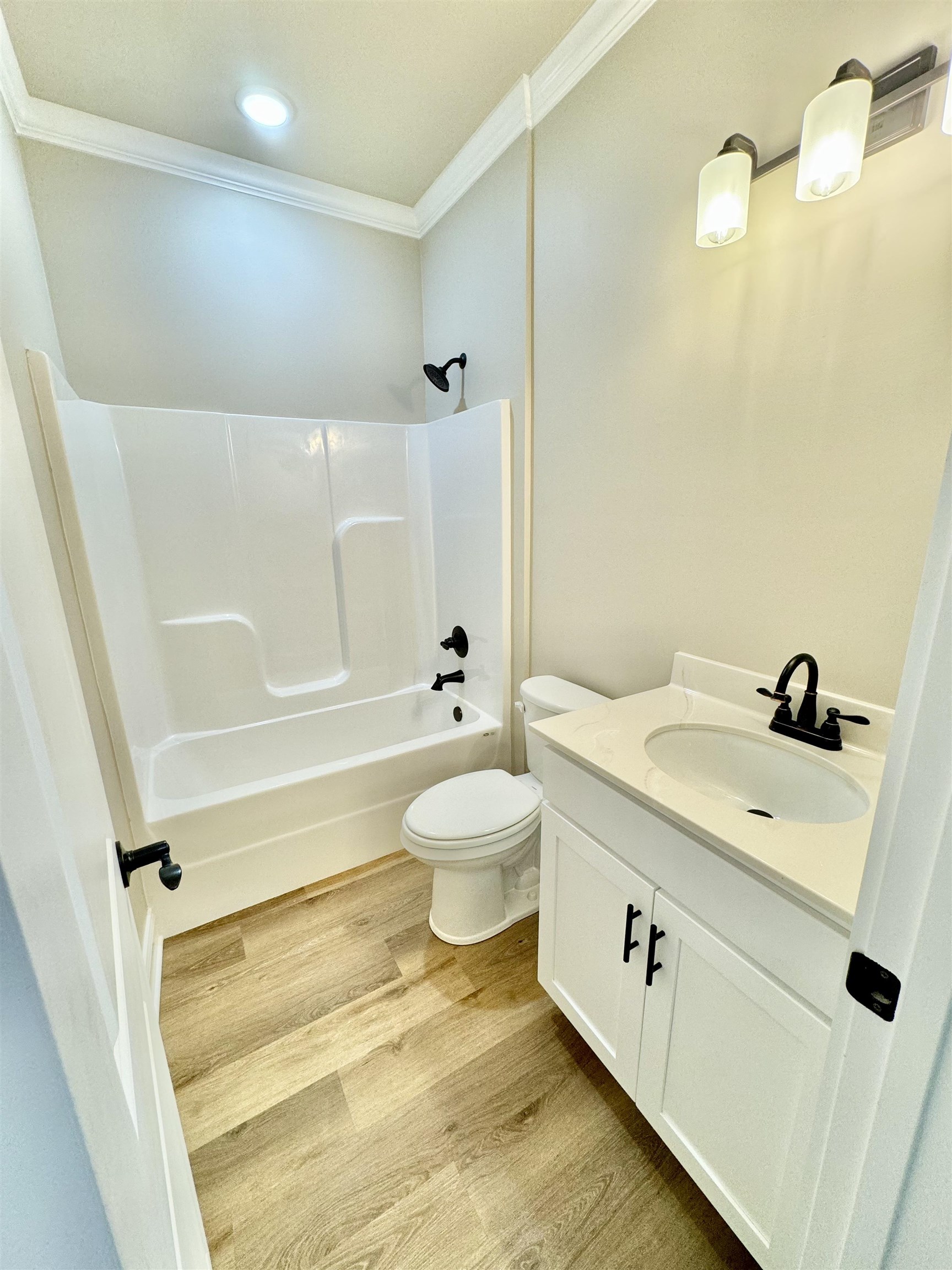 210 Church Street Ripley, TN 38063 - Photo 12 of 14 Full bathroom with shower / bath combination, wood-type flooring, ornamental molding, toilet, and vanity