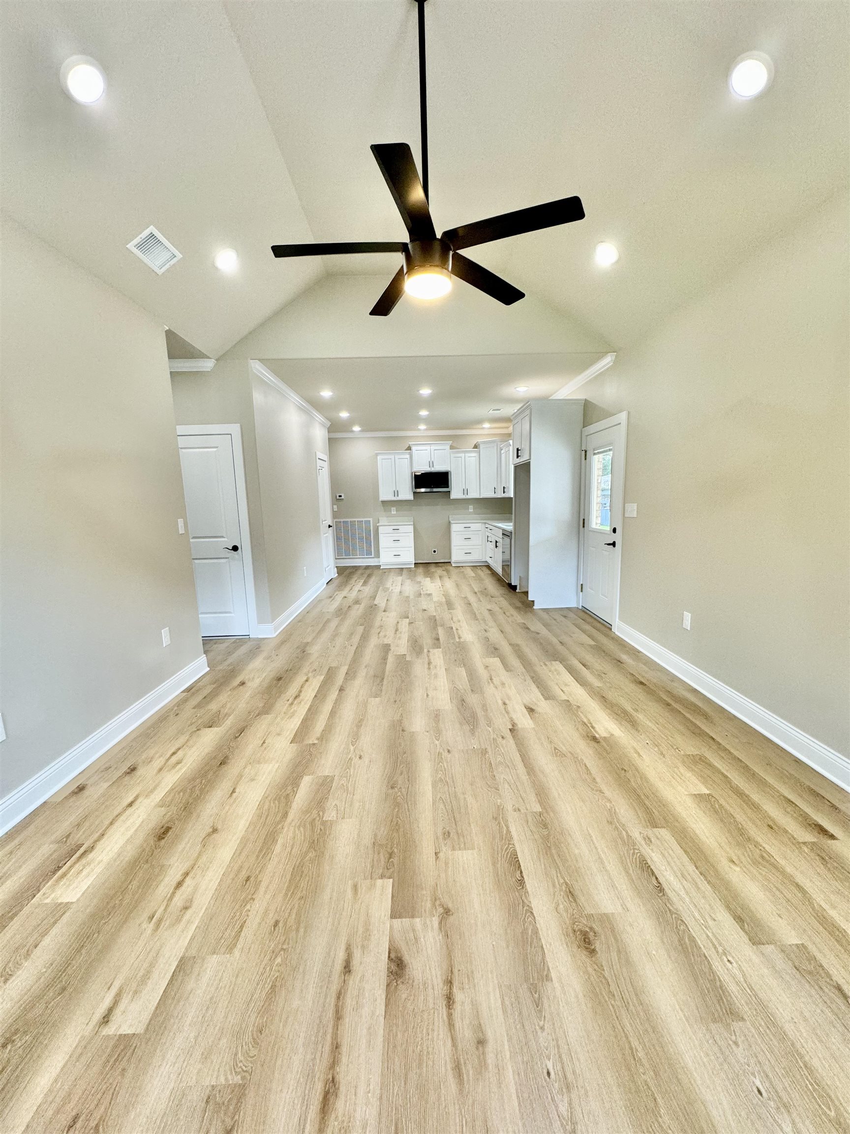 210 Church Street Ripley, TN 38063 - Photo 3 of 14 Unfurnished living room featuring lofted ceiling, light wood-type flooring, and ceiling fan