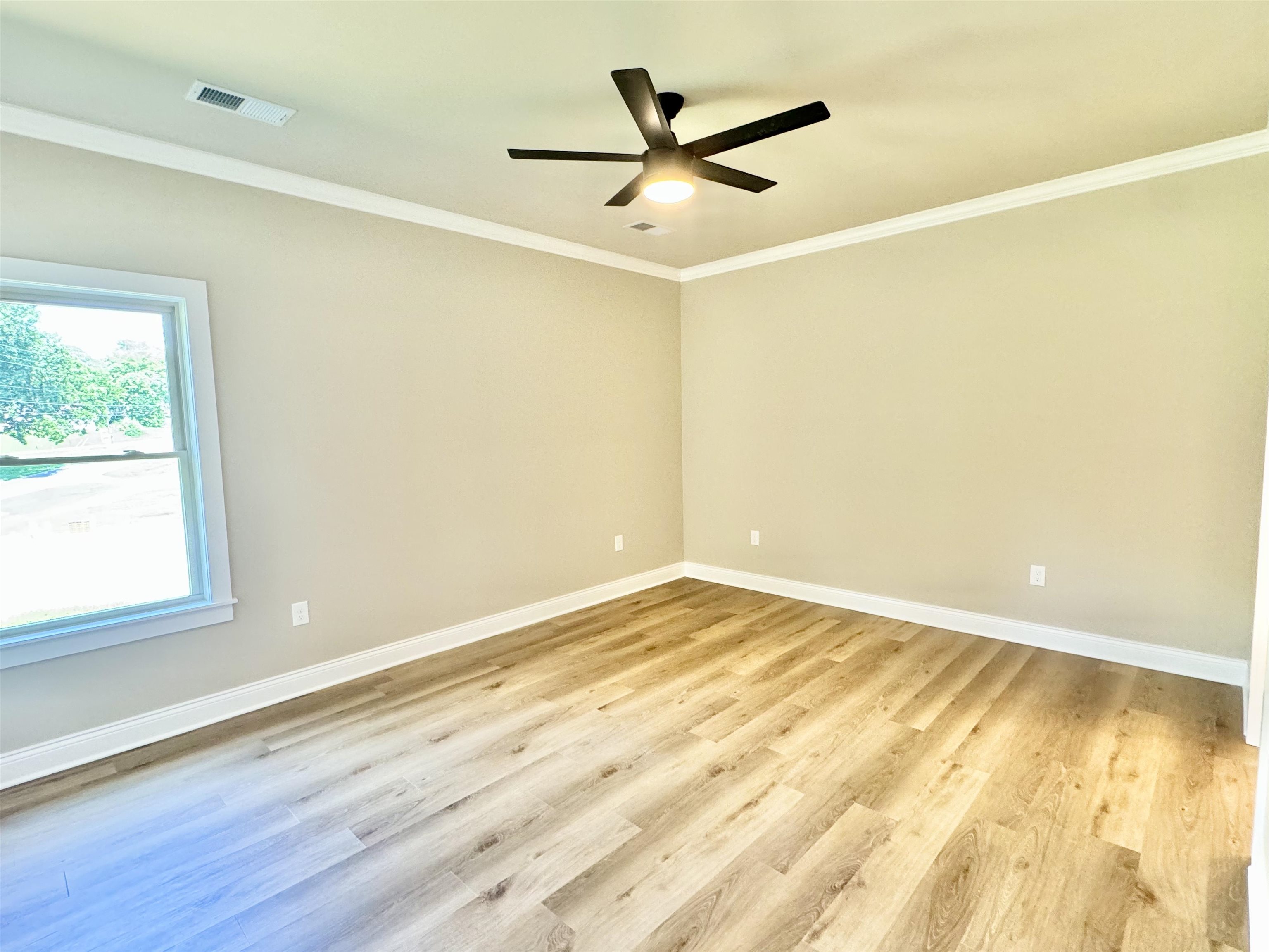 210 Church Street Ripley, TN 38063 - Photo 6 of 14 Empty room with light hardwood / wood-style floors, crown molding, and ceiling fan