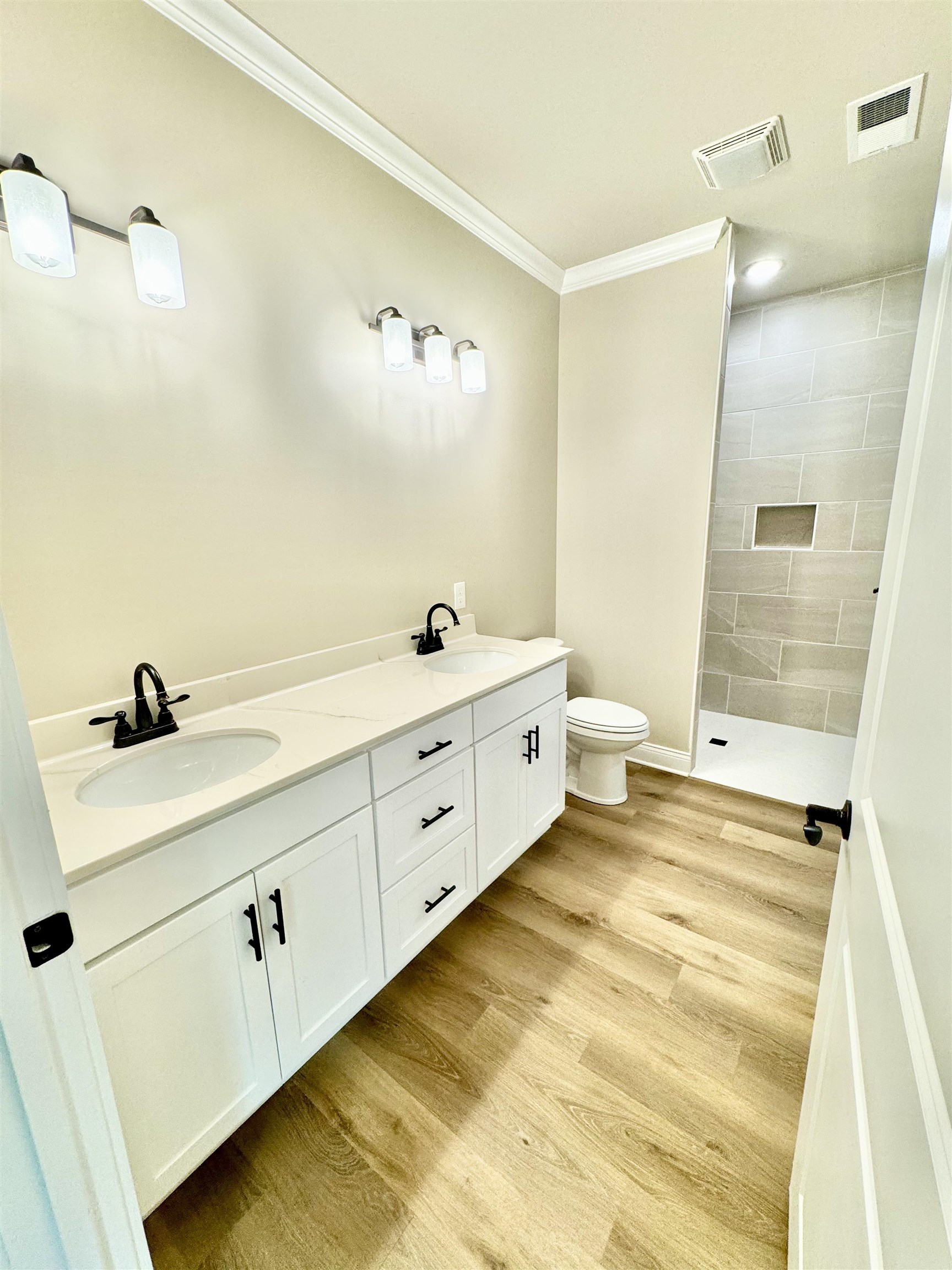 210 Church Street Ripley, TN 38063 - Photo 7 of 14 Bathroom with double sink vanity, ornamental molding, wood-type flooring, and toilet