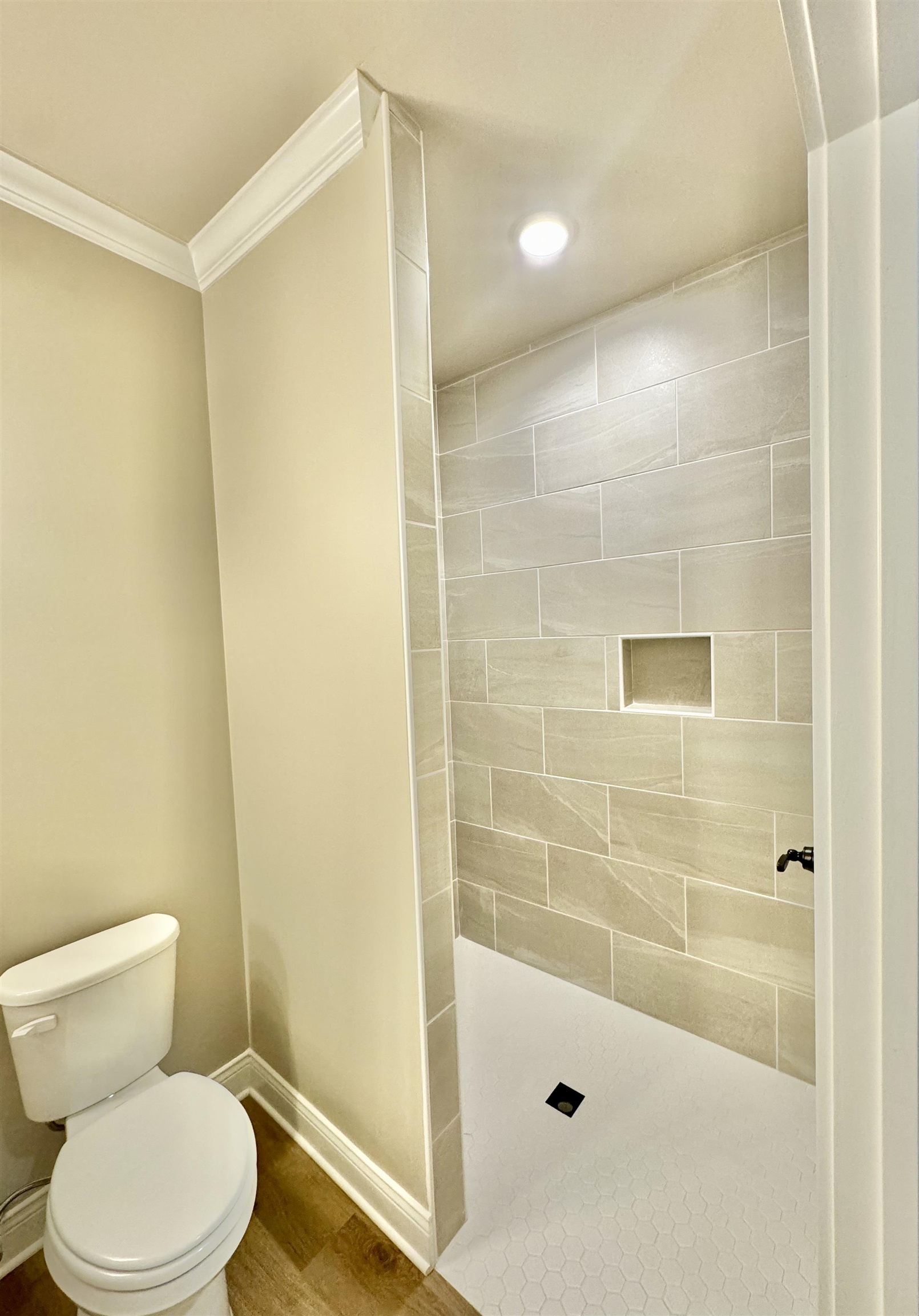 210 Church Street Ripley, TN 38063 - Photo 8 of 14 Bathroom with crown molding, wood-type flooring, a tile shower, and toilet