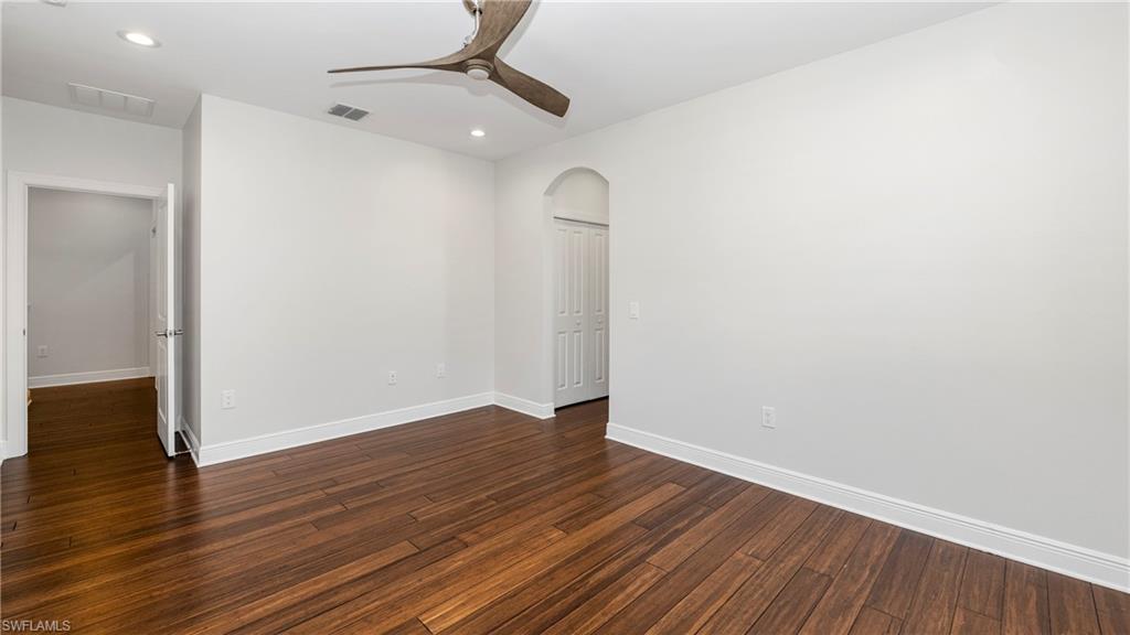1238 Kendari Terrace Naples, FL 34113 - Photo 23 of 50 Spare room with arched walkways, ceiling fan, recessed lighting, and dark wood-type flooring
