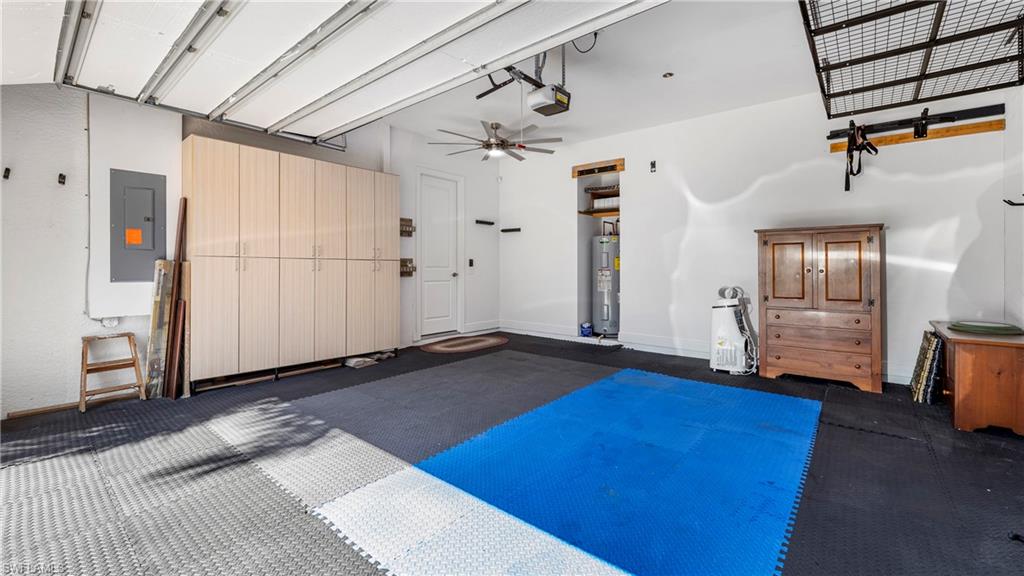 1238 Kendari Terrace Naples, FL 34113 - Photo 33 of 50 Garage with electric panel, a ceiling fan, electric water heater, and a garage door opener