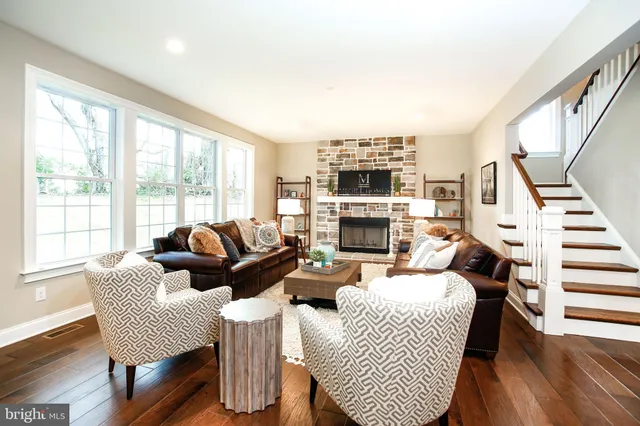 a living room with fireplace furniture and a large window