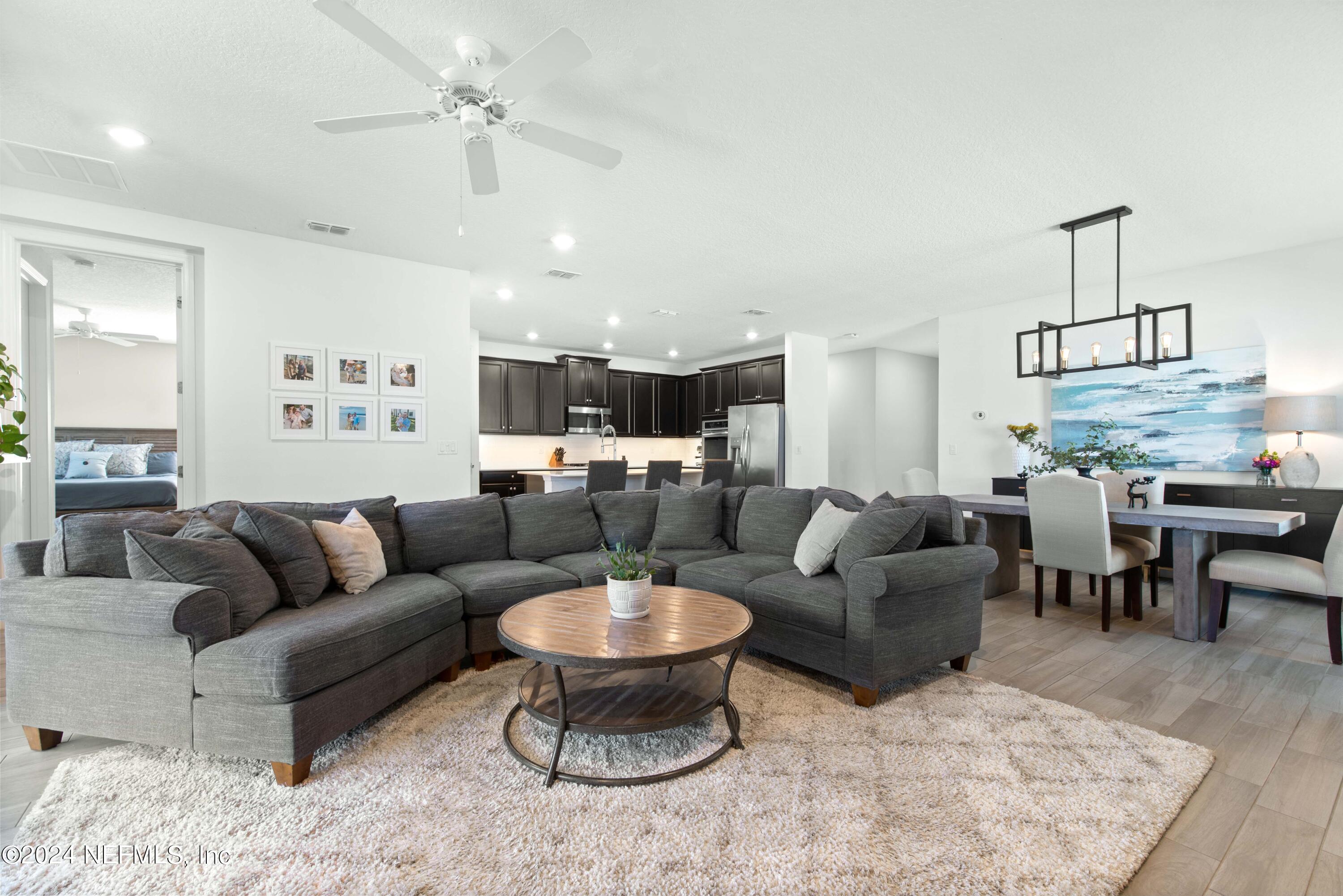 2672 Alexia Circle Jacksonville, FL 32246 - Photo 11 of 33 a living room with furniture kitchen view and a chandelier