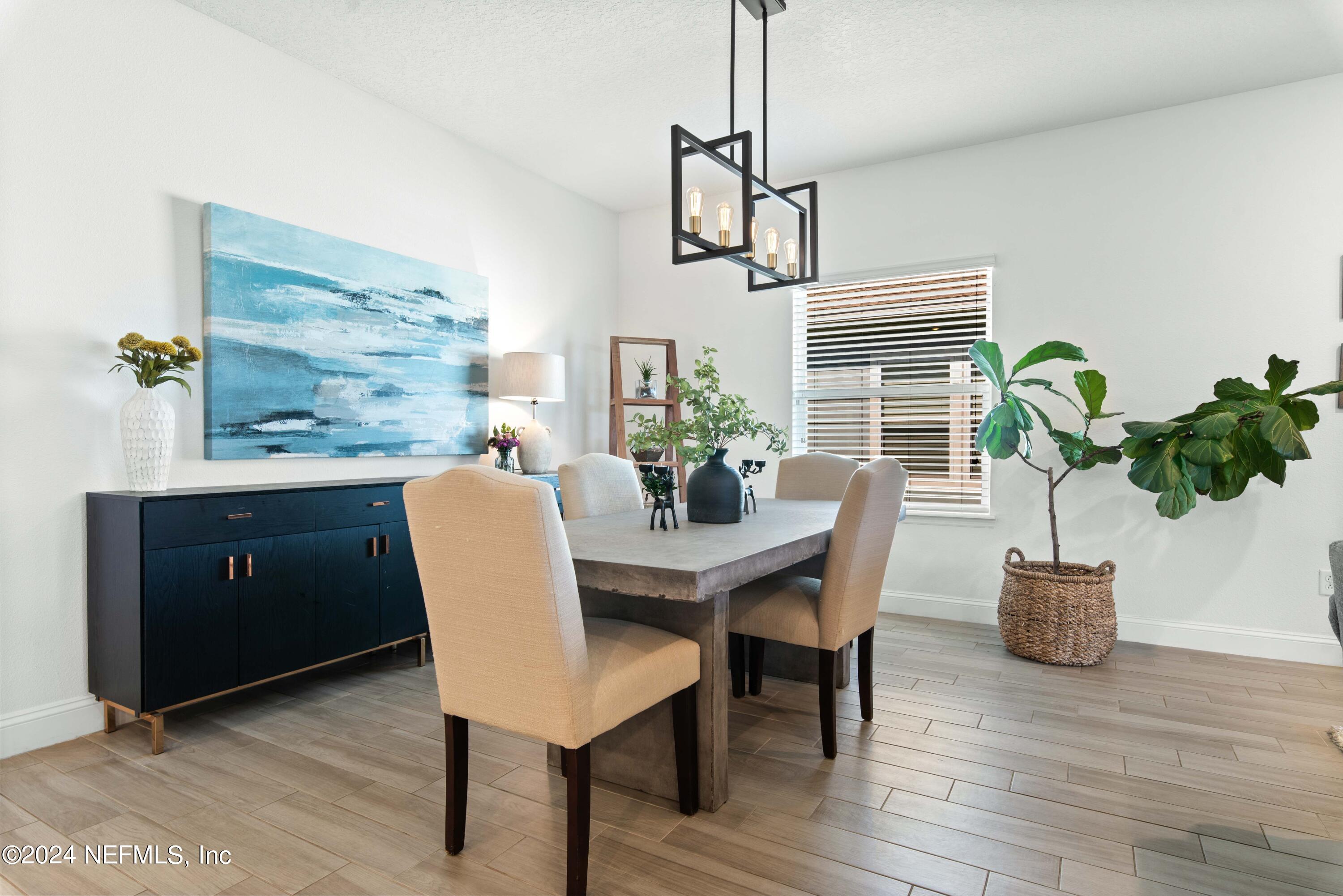 2672 Alexia Circle Jacksonville, FL 32246 - Photo 12 of 33 a dining room with furniture potted plants and wooden floor