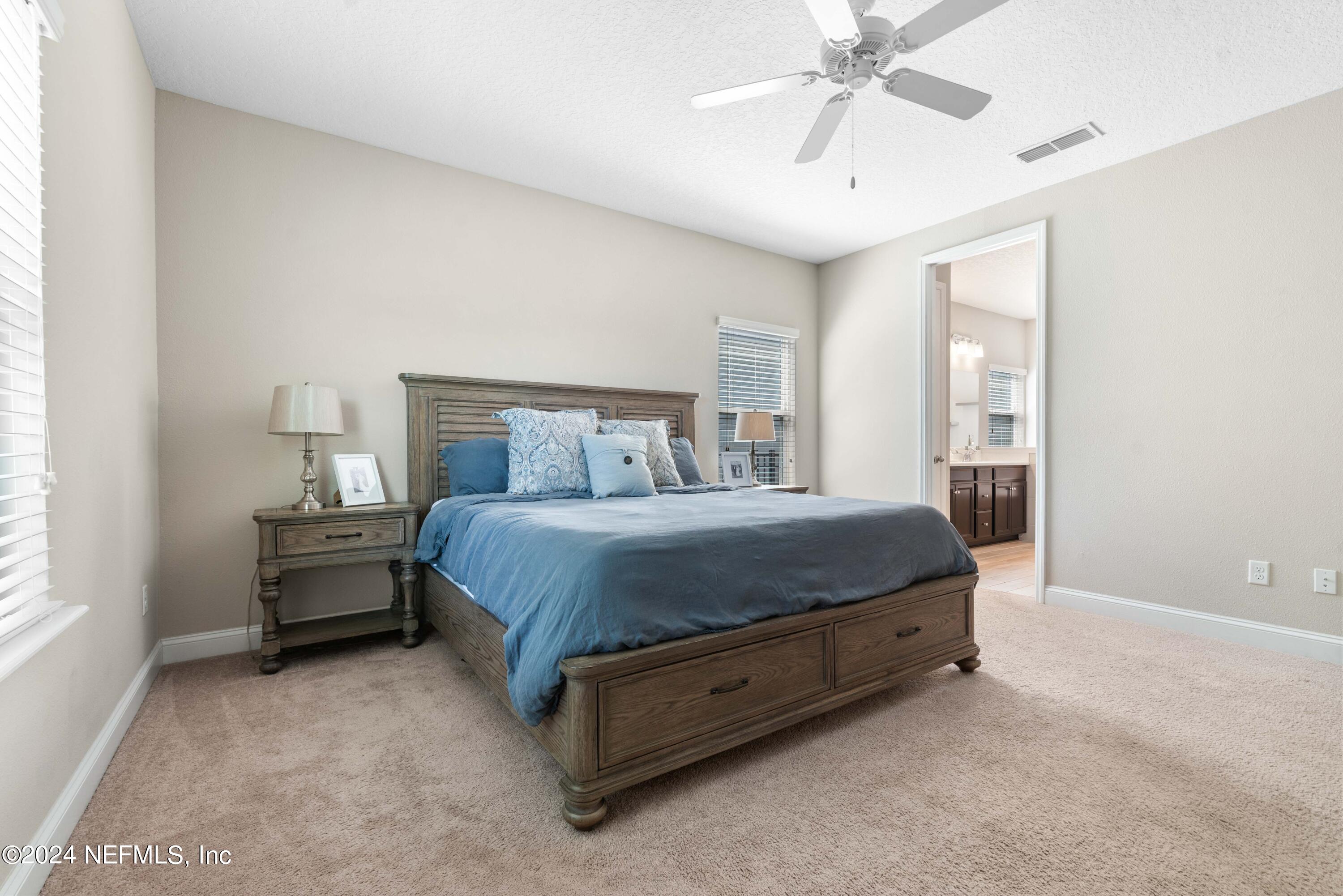 2672 Alexia Circle Jacksonville, FL 32246 - Photo 14 of 33 a spacious bedroom with a bed and a chandelier