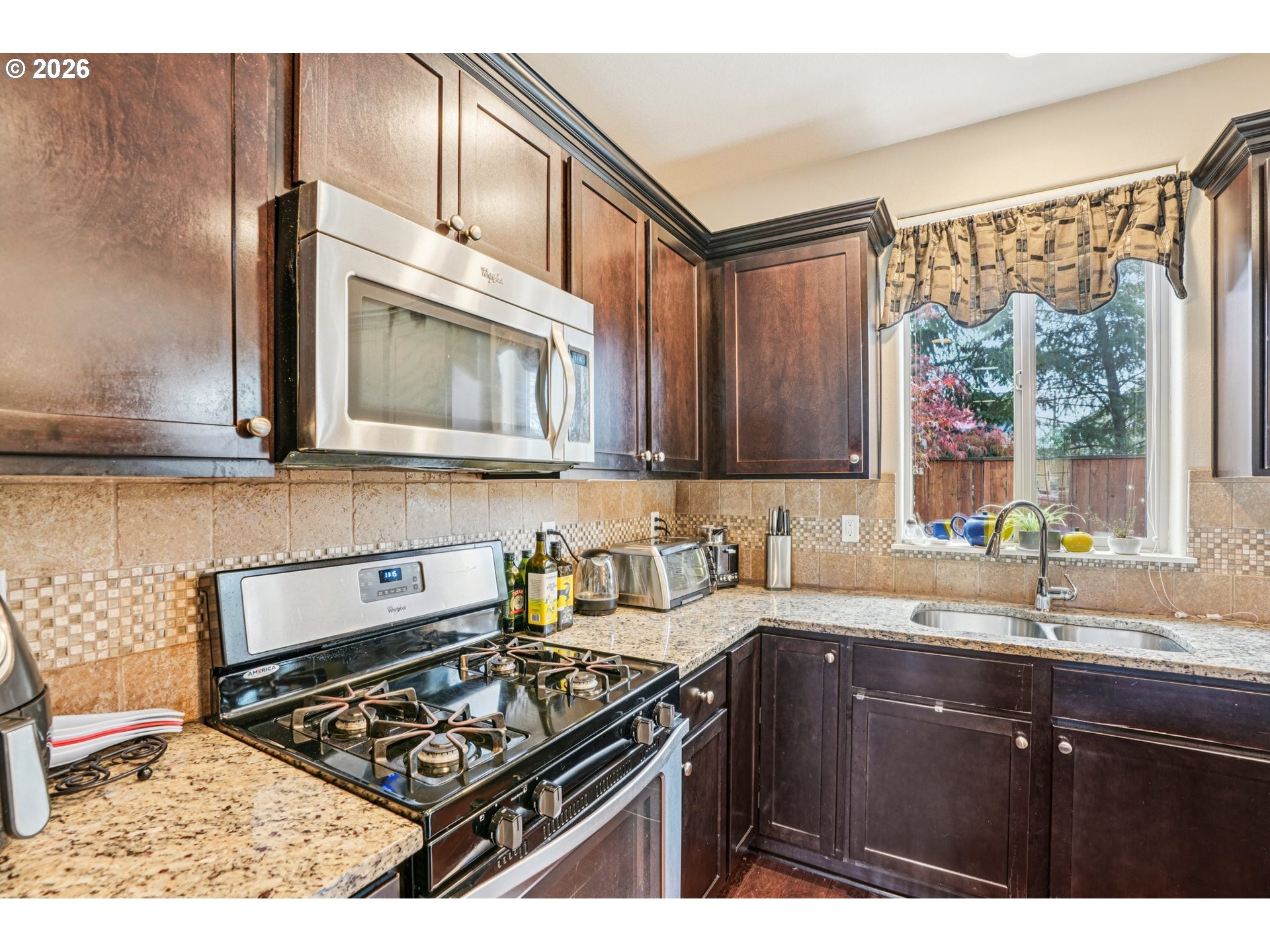16958 Southwest Kavitt Lane Beaverton, OR 97078 - Photo 11 of 30 a kitchen with stainless steel appliances a sink stove and cabinets