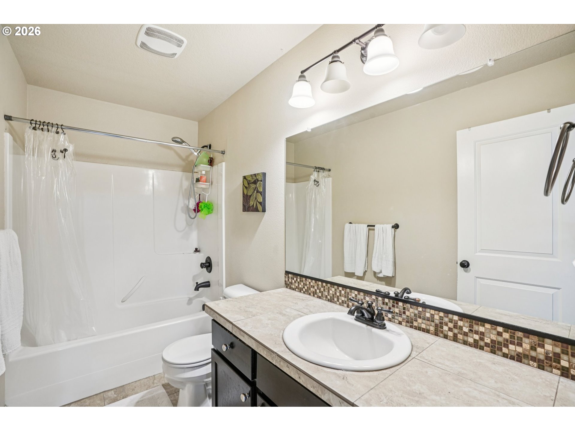 16958 Southwest Kavitt Lane Beaverton, OR 97078 - Photo 24 of 30 a bathroom with a granite countertop sink a mirror a bathtub and shower
