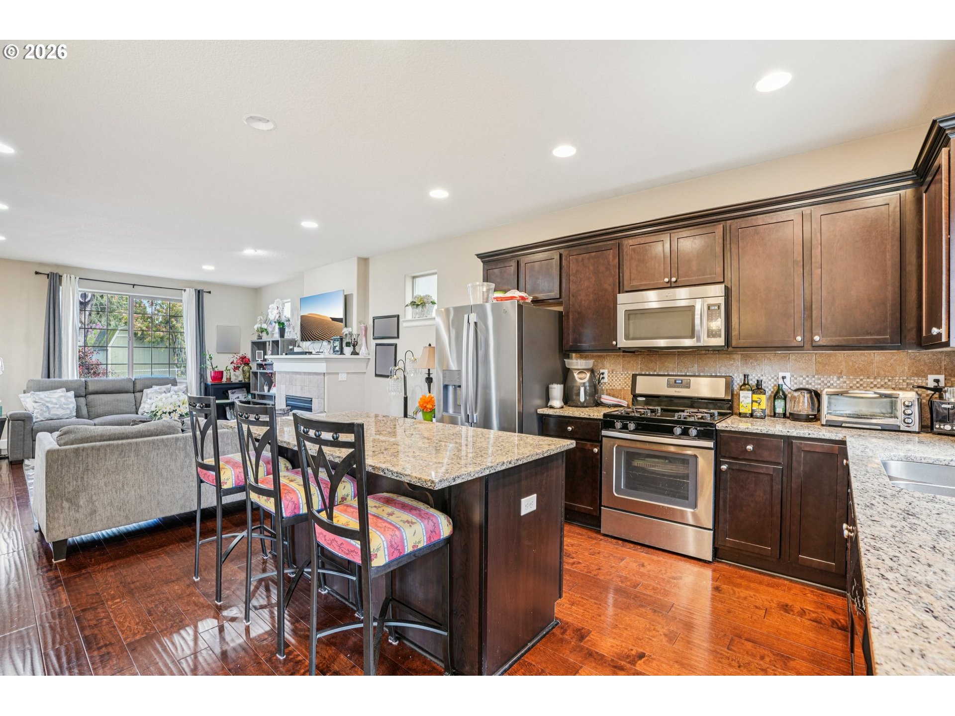 16958 Southwest Kavitt Lane Beaverton, OR 97078 - Photo 9 of 30 a kitchen with stainless steel appliances kitchen island granite countertop a table chairs and a refrigerator