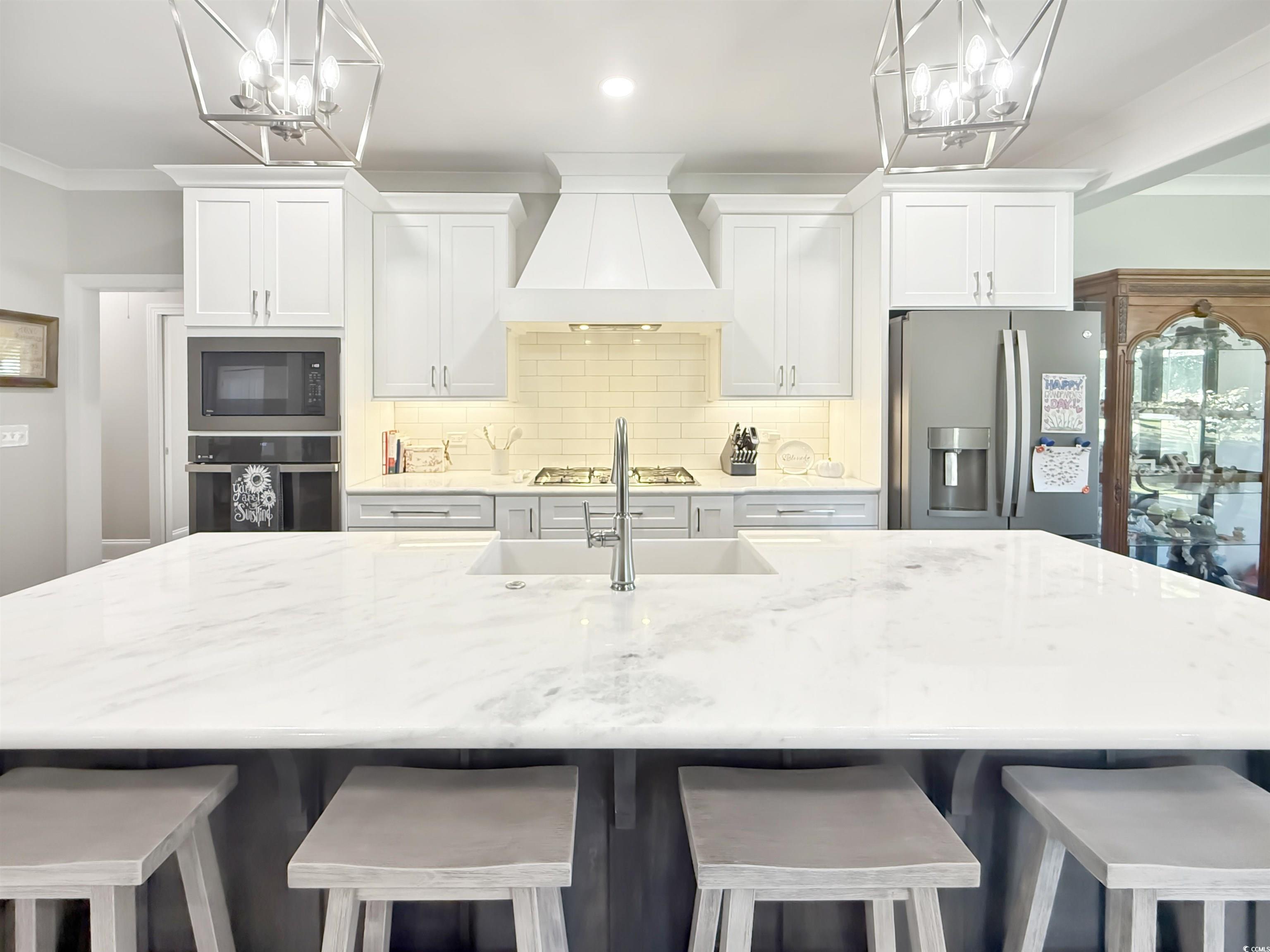 521 Oak Lawn Road Georgetown, SC 29440 - Photo 13 of 40 Kitchen with a chandelier, a kitchen bar, premium range hood, a center island with sink, and stainless steel appliances