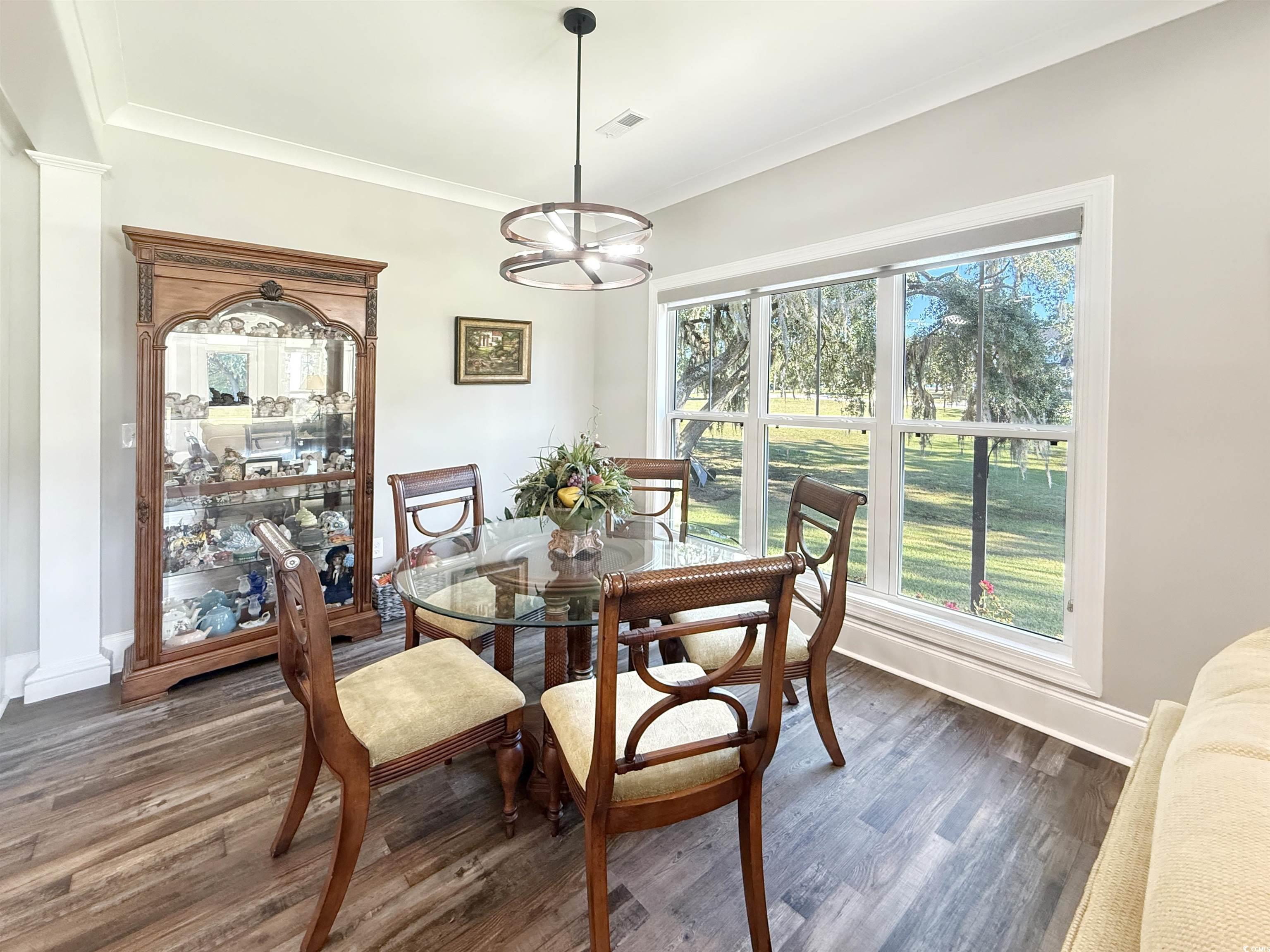 521 Oak Lawn Road Georgetown, SC 29440 - Photo 19 of 40 Dining area with wood finished floors, a chandelier, and crown molding