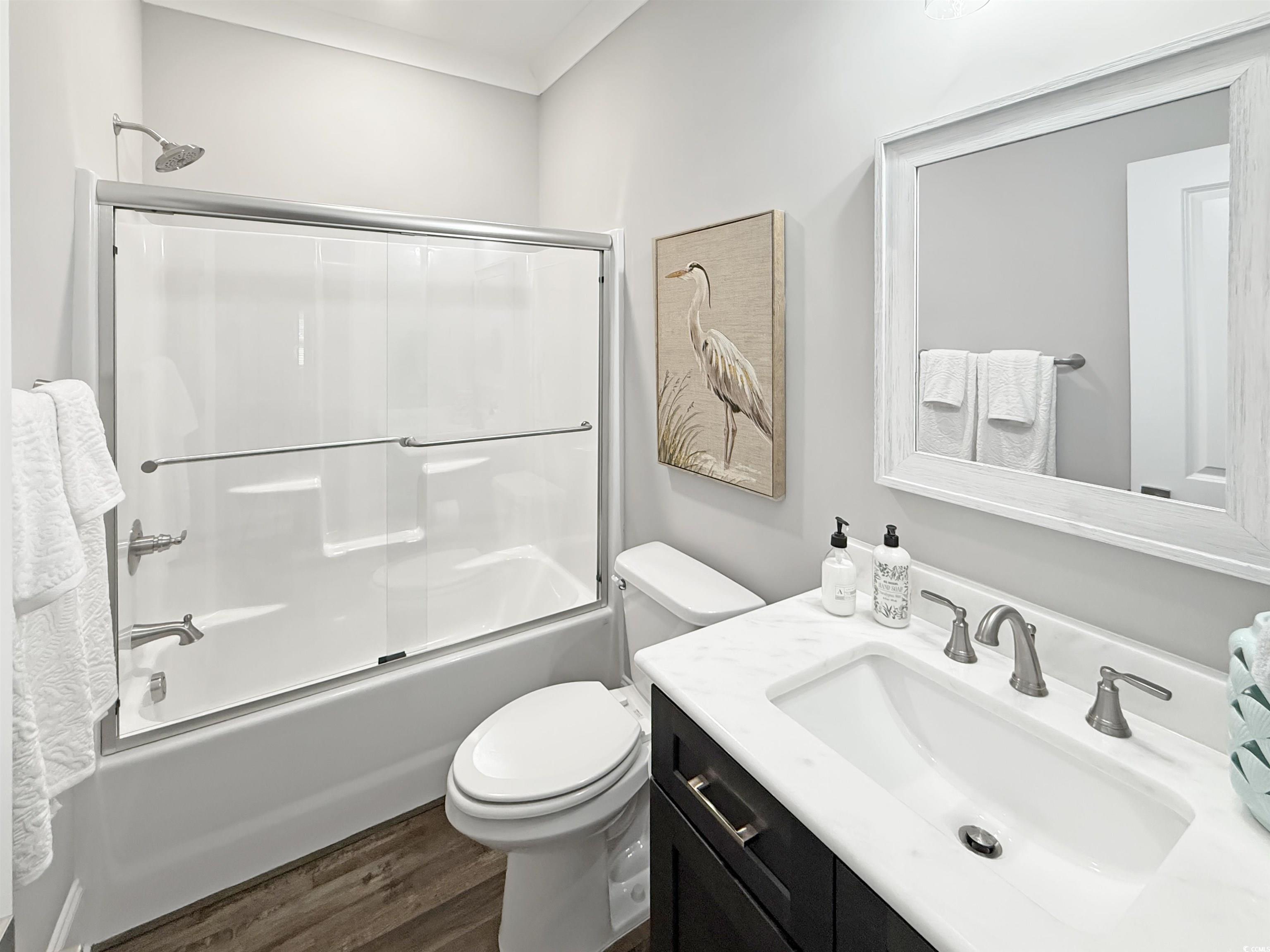 521 Oak Lawn Road Georgetown, SC 29440 - Photo 37 of 40 Full bath featuring bath / shower combo with glass door, vanity, and dark wood-type flooring