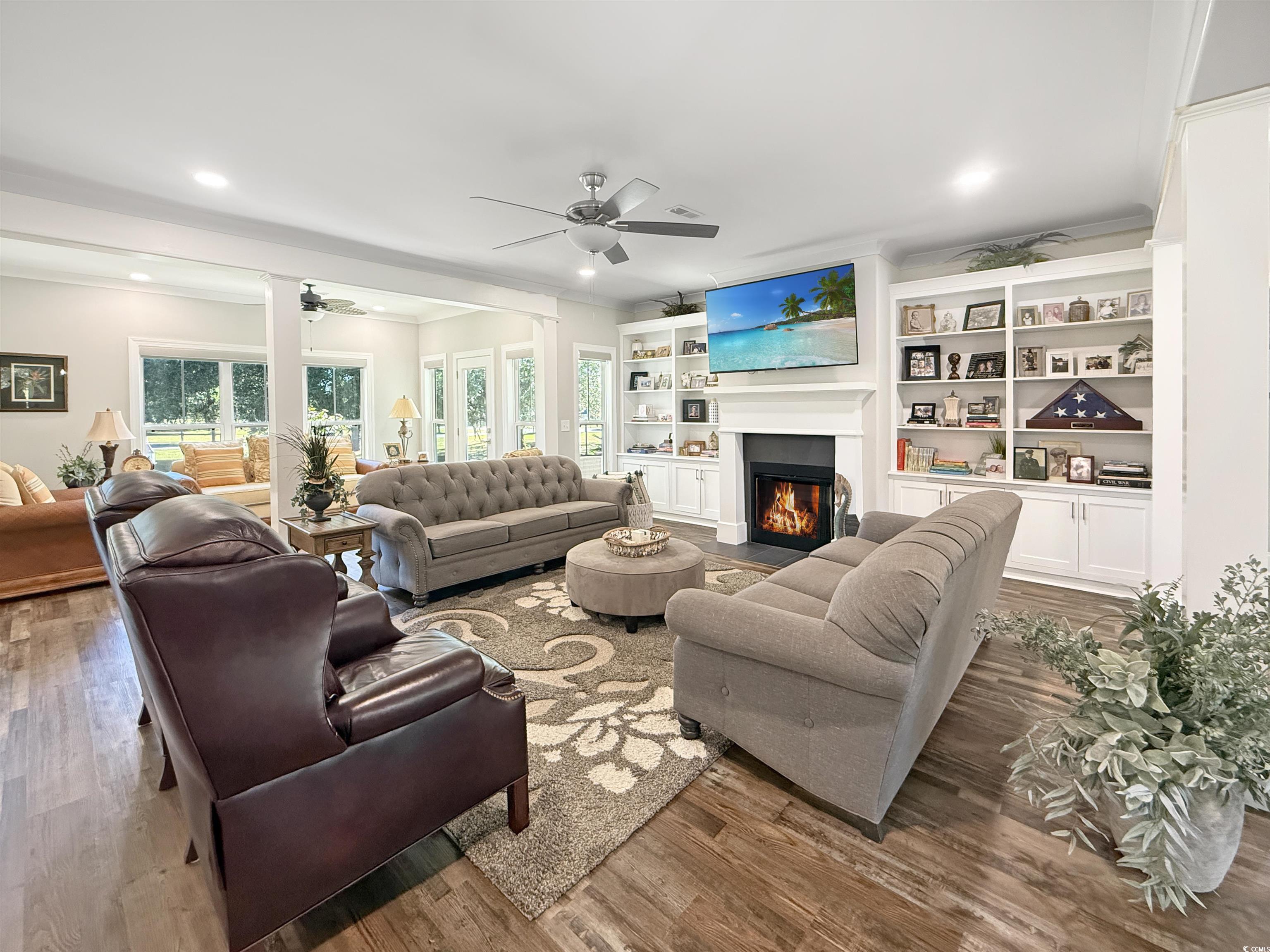 521 Oak Lawn Road Georgetown, SC 29440 - Photo 10 of 40 Living area featuring a fireplace with flush hearth, wood finished floors, built in shelves, crown molding, and recessed lighting