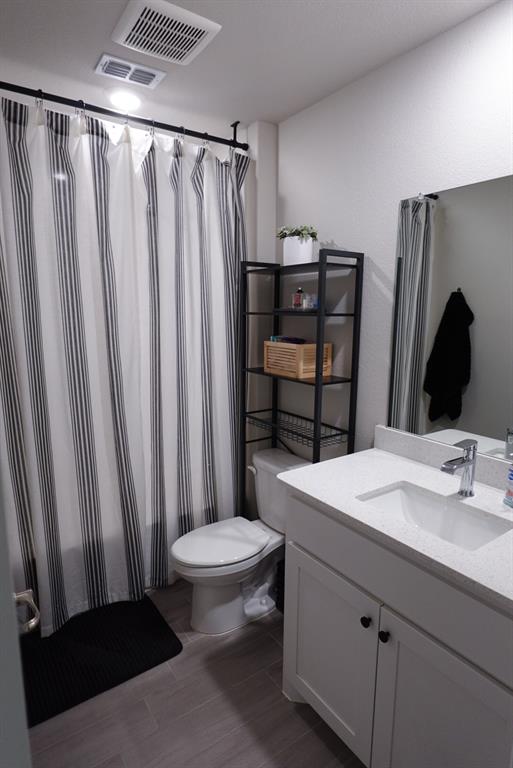 1913 Cookes Lane Cleburne, TX 76033 - Photo 12 of 20 a bathroom with a sink a toilet a mirror and shower curtain