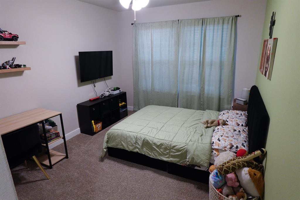 1913 Cookes Lane Cleburne, TX 76033 - Photo 14 of 20 a bedroom with a bed and a flat tv screen on dresser