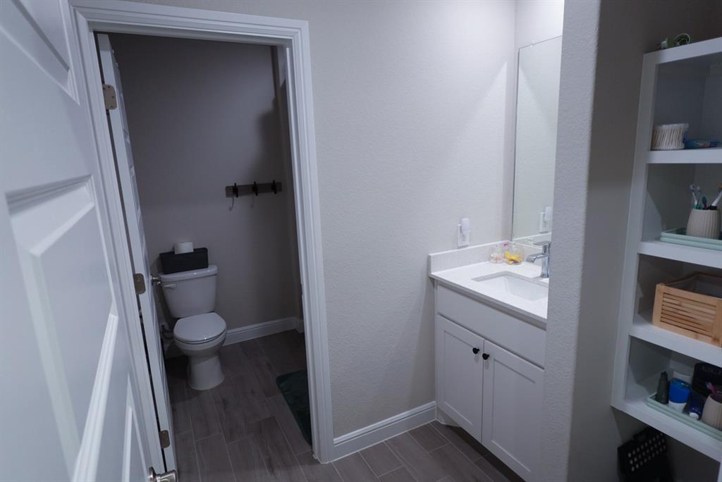 1913 Cookes Lane Cleburne, TX 76033 - Photo 16 of 20 a bathroom with a toilet sink and a mirror
