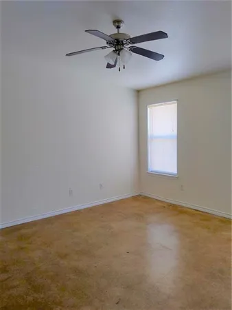 an empty room with a window and a fan