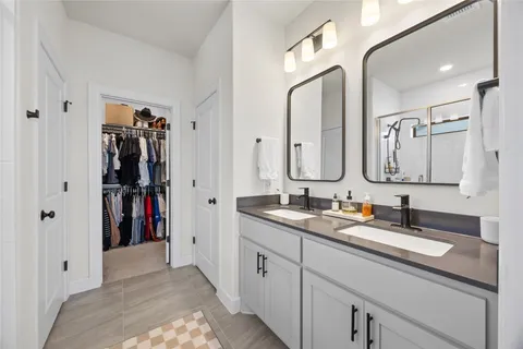 a en suite bathroom with a double vanity sink and a mirror