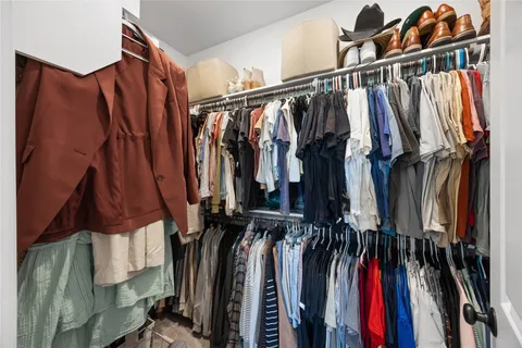 a view of walk in closet with clothes and shoes