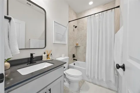 a bathroom with a granite countertop sink toilet and shower