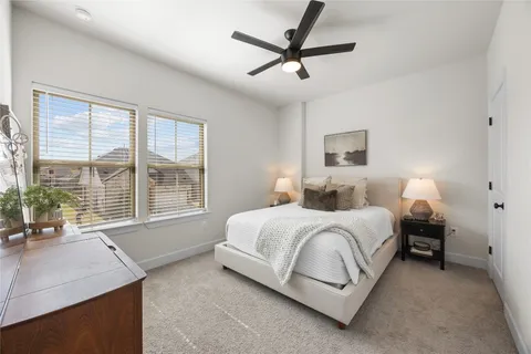 a spacious bedroom with a bed a chandelier and a large window