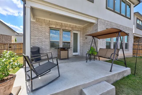 a view of a patio with table and chairs potted plants and a large tree