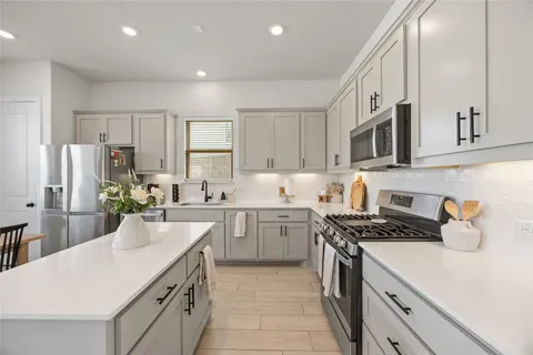 a kitchen with a sink stove top oven and refrigerator
