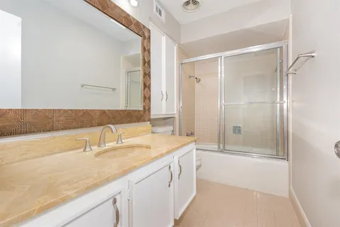 a bathroom with a sink and a mirror with bathtub