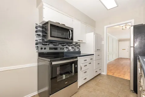 a kitchen with stainless steel appliances white cabinets and a stove