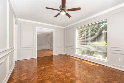 a view of an empty room with a window and a kitchen