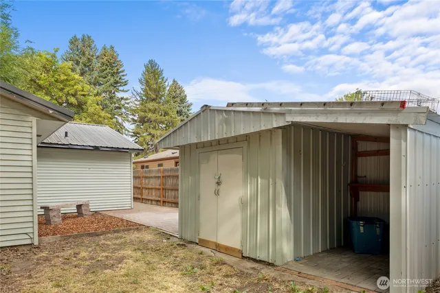 a backyard of a house with large trees and garage