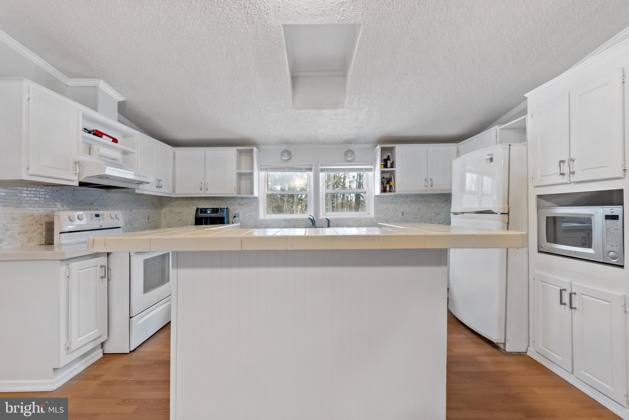 233 Short Road Kearneysville, WV 25430 - Photo 14 of 36 a kitchen with kitchen island white cabinets and white appliances