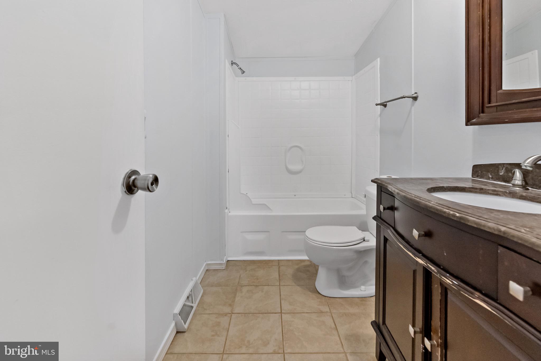 233 Short Road Kearneysville, WV 25430 - Photo 28 of 36 a bathroom with a granite countertop toilet a sink and a shower